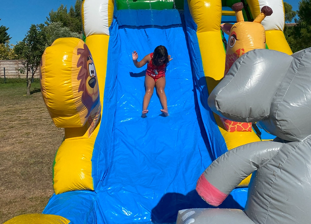 Enfant qui glisse sur le toboggan aquatique gonflable Savane