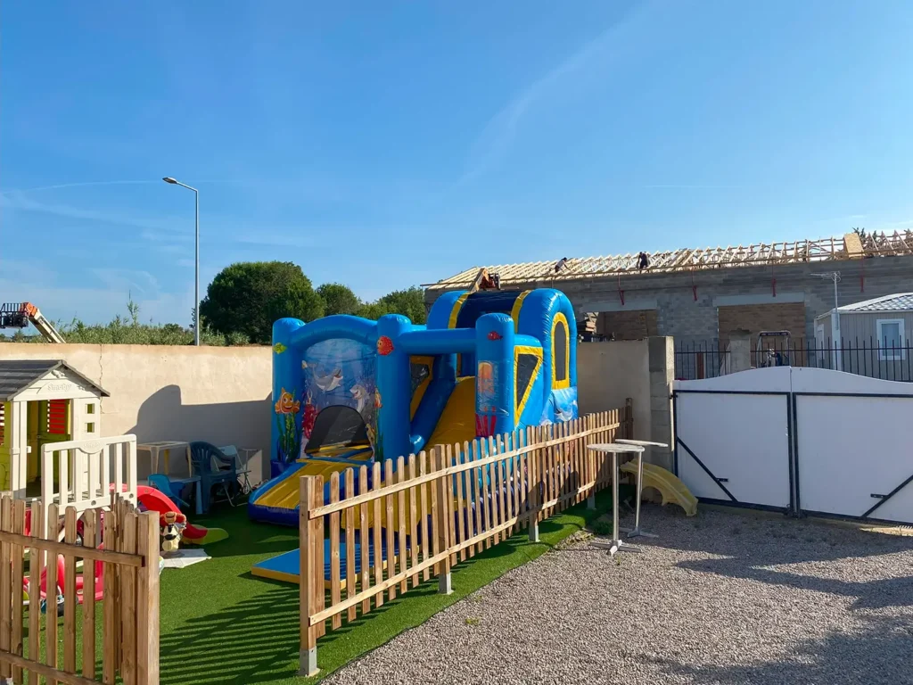Château gonflable Jumpy Happy Océan dans un jardin clôturé