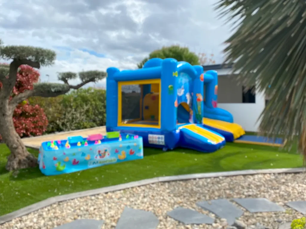 Château gonflable Jumpy Happy Océan et stand de pêche aux canards dans un jardin
